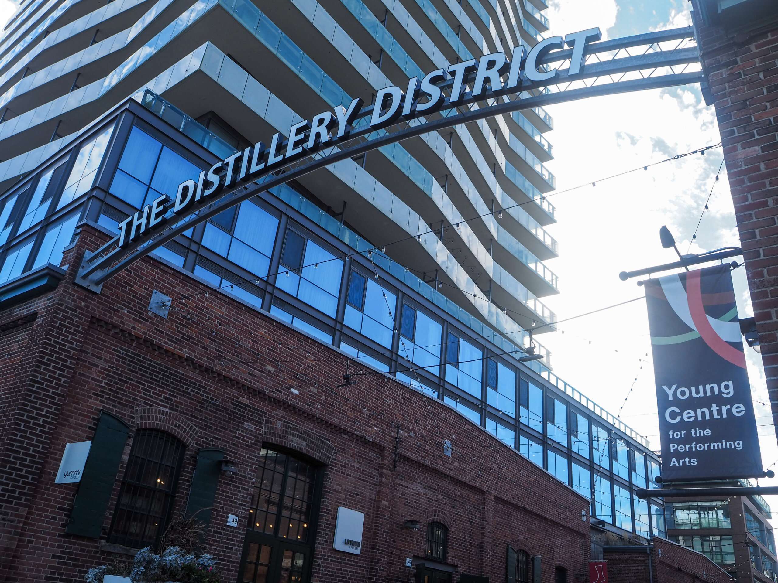 a black and white sign with distillery district written on it in between two buildings