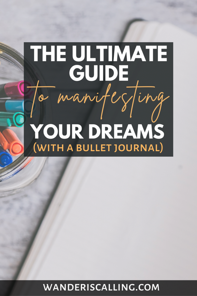 the ultimate guide to manifestation bullet journal with a background of an open empty page and colorful pens in a jar