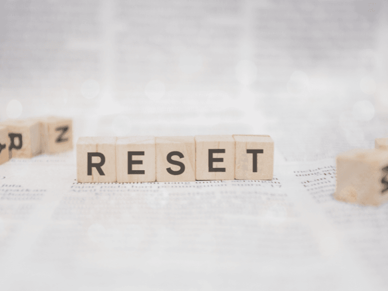 New year reset with small wooden blocks it says reset on top of an black and white article layout